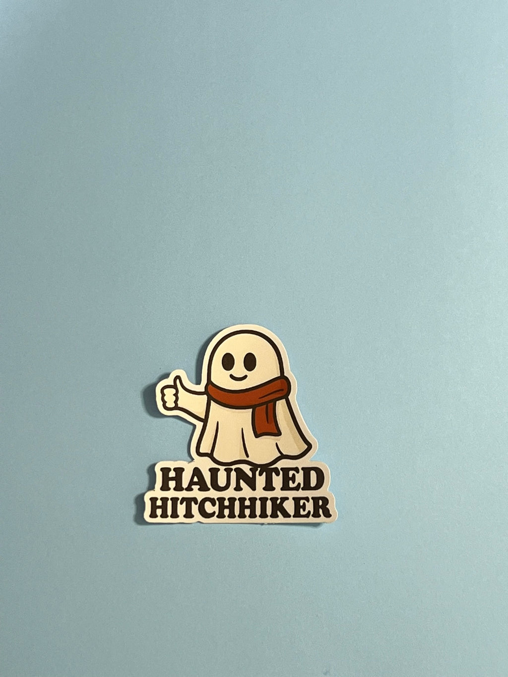 Haunted Hitchhiker Sticker – Cozy Ghost with Scarf Vinyl Sticker